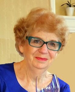 Front facing close-up of Anthea holding a wine glass